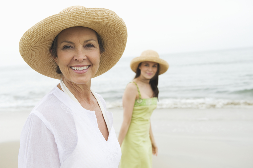 Portrait,Of,Happy,Senior,Woman,And,Daughter,Walking,At,Beach
